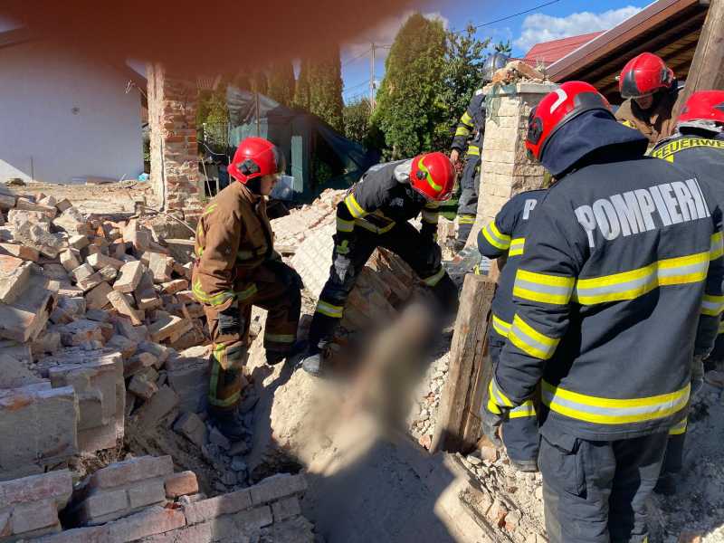Două persoane, prinse sub un perete care s-a dărâmat